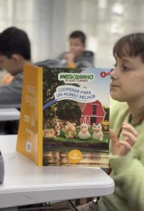 Estudantes recebem o livro do projeto durante a Senef - SENEF 2026: Cresol leva educação financeira para escolas em diferentes regiões do Brasil