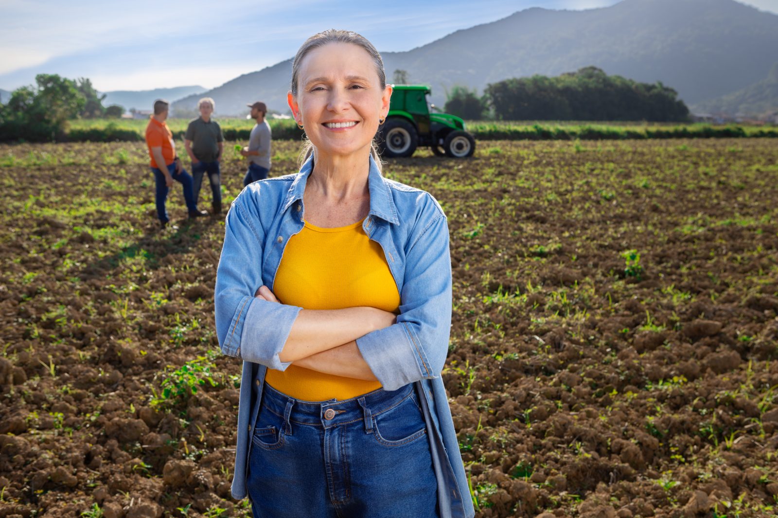 Agricultora familiar no campo de braços cruzados sorrindo